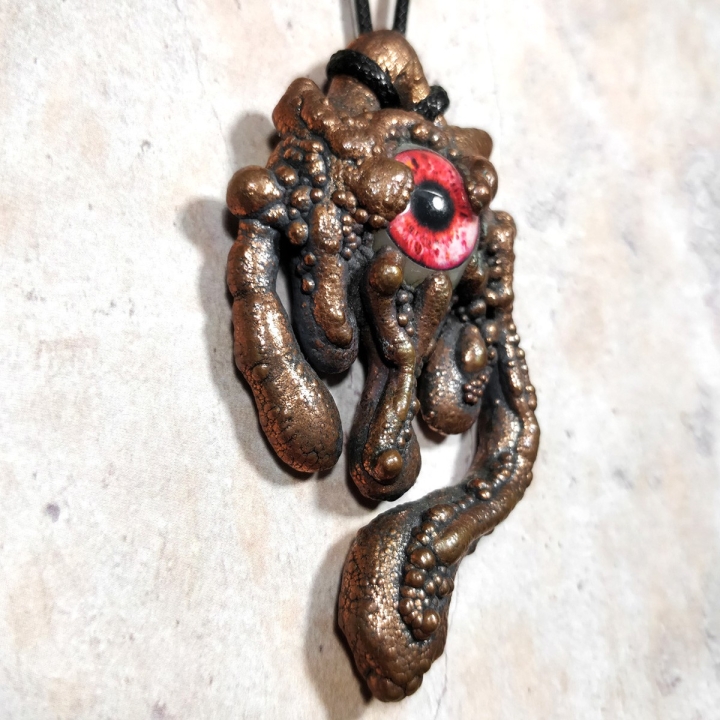 Pendentif dégoulinant  cuivre oeil rouge résine pustule glauque